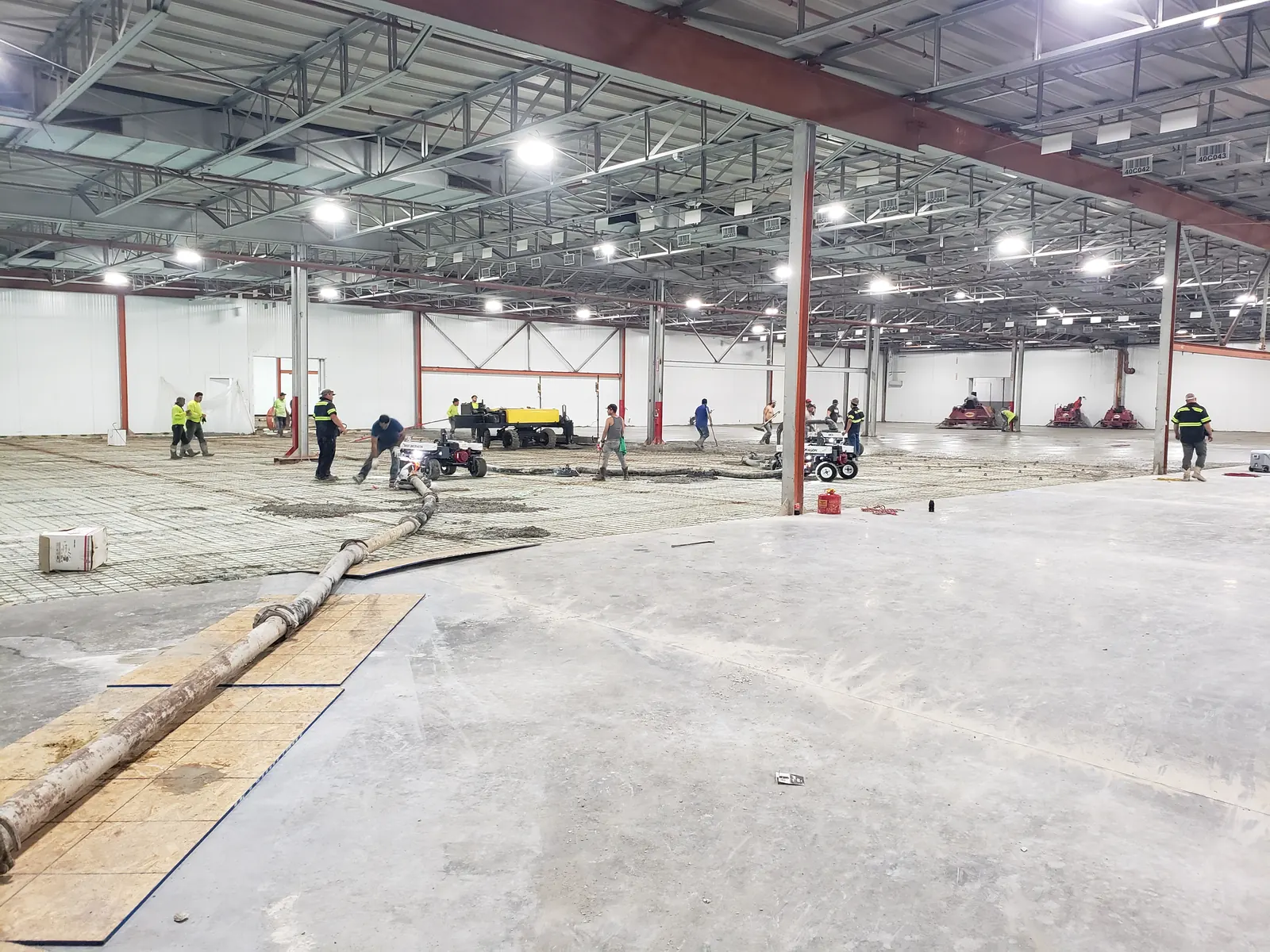 Concrete placement and finishing inside the FW Logistics warehouse, with a slab section in the foreground